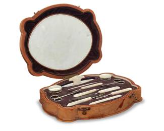 2248 A vintage Casa Escasany manicure grooming set Early/mid-20th century Label to base: Casa Escasany; impressed stamp to base: Made in Austria The large shaped wooden case covered in tan leather with gilt embossed trim, the purple velvet interior with twelve mother of pearl and metal manicure tools and other items set in shaped depressions, including a nail buffer, two pairs of small scissors, two diminutive glass jars with mother of pearl lids, a file, and cuticle tools, with oval mirror to lid 12 pieces Case: 2.25" H x 11" W x 9.25" D Estimate: $300 - $500