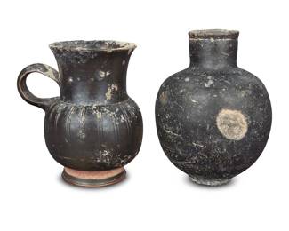 2020 Two Apulian/Gnathian blackware vessels Circa 4th century BCE, Etruscan; Magna Grecia Comprising a thistle cup, and a black glazed olpe vessel 2 pieces Thistle: 4.375" H x 4" W x 3.25" D Estimate: $400 - $600