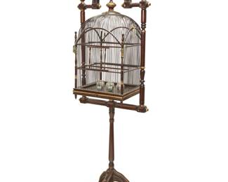 2141 A Chinese style carved wood birdcage Mid/late 20th century With reeded and turned wood cage with slide-out floor, suspended on a parcel-gilt turned wood frame with tripod base, together with five polychrome porcelain jars and carved hardstone or metal medallion accents Overall: 74" H x 25" W x 17" D; Cage with hanging hardware: 30.5" H x 25" W x 25" D Estimate: $400 - $600