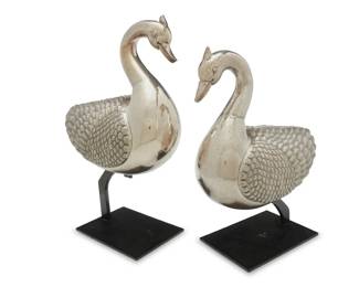 2142 A pair of silvered metal geese 20th century Each weighted silver-plated copper, set on an enameled metal stand 2 pieces Each goose: 15" H x 14" W x 8.5" D approximately; Taller stand: 7.5" H x 10" W x 7" D Estimate: $500 - $800