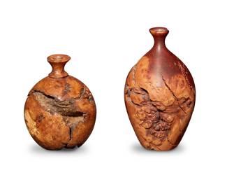 2275 Bruce Bernson (1950-2014) Two burlwood bud vases, late 20th century One incised near base: Bruce Bernson / usa '81' / Wild Lilac Burl; the other incised: Bruce Bernson / Oak Burl Each globular turned wood vessel with flared rim fitted with a glass insert 2 pieces Larger: 9.875" H x 5.75" Dia.; Smaller: 7.75" H x 5.625" Dia. Estimate: $200 - $300