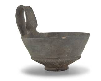 2017 An Etruscan Bucchero pottery kyathos 7th-5th century BCE or later The drinking cup with incised accents to handle and body 5" H x 5.375" W x 6.625" D Estimate: $200 - $400