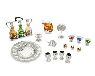 2255 A Farber Brothers barware set Early/mid-20th century; New York, NY Most variously marked for Faber Brothers Each glass with metal overlay, comprising a tantalus with three bottles, another decanter, four dessert cups, one taller dessert vessel, and three shot glasses, together with four Chase U.S.A. nickel-plated copper goblets, a nickel-plated charger, and a nickel alloy turtle-form toothpick holder 16 pieces Tantalus overall: 10.5" H x 13" W x 3.75" D; Each dessert cup: 3.625" H x 3.875" Dia. Estimate: $100 - $200