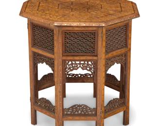 2029 An Indian style octagonal folding side table 20th century The tambour-form table with inlaid copper and brass foliate elements, the top depicting a star medallion, the supports collapsible and joined by intricate openwork stretchers 20.5" H x 20" W x 20" D Estimate: $300 - $500