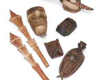 2031 A group of seven carved wood masks and clubs Early 20th century Comprising a Mossi antelope mask, two Oceanic war clubs with inlaid mud accents, a Central American Huale mask with armadillo headpiece and animal hair elements, an African Baule mask, and one other mask 7 pieces Largest mask: 14" H x 7" W x 3.75" D; Larger club: 28" L x 5" W x 1.75" D Estimate: $200 - $400