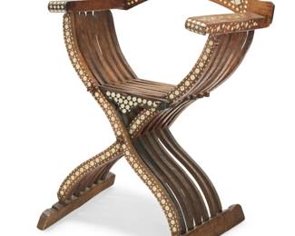 2024 A Levantine inlaid carved hardwood savonarola chair 19th/20th century With curved supports and a slatted seat and back, profusely inlaid with bone and mother-of-pearl elements arranged in geometric patterns along the crest rail, arms, and legs 37.5" H x 30" W x 25.5" D Estimate: $400 - $600