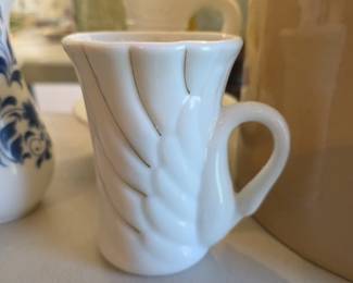 white porcelain mug features a swan-shaped design with gold trim accents.
