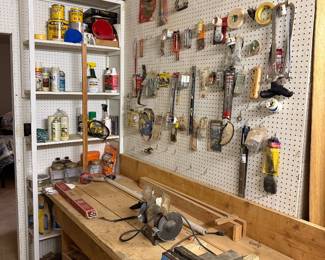 Blue Olympia brand bench vice with rotating base, vintage bench grinder, various woodworking tools and equipment
