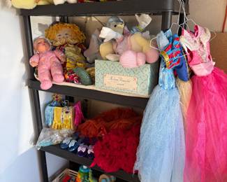 Various toys and play items, including dress up, craft set, vintage, Barbie and Tupperware toy. Disneyland stuffed animals and a Madame Alexander doll among other things.