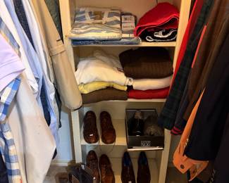 Men’s closet with shoes, belts, and ties and suits and nice button-down shirts