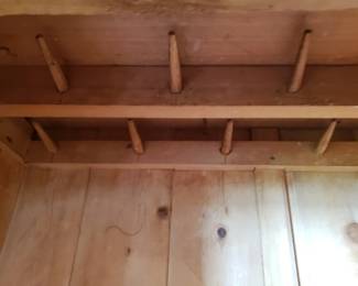 In the top of the antique wardrobe are pegs for hanging clothing