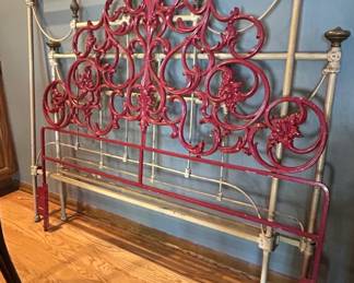 Victorian Cast Iron Bed Frame with Red Decorative Panel and Ornate Scrollwork