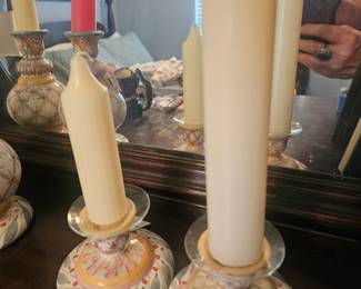 Hand-painted ceramic candle holders by MacKenzie-Childs with floral and geometric designs.