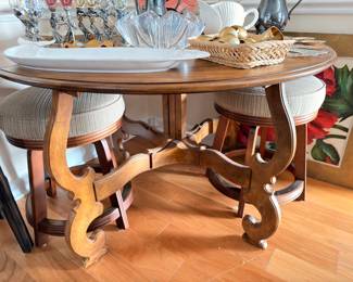 Round carved wood dining table with upholstered stools