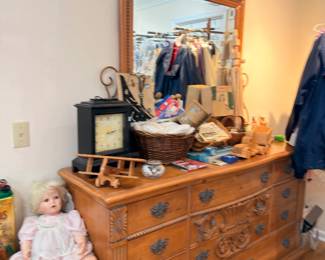 Carved oak dresser with mirror, porcelain doll, clock