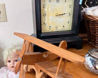 Mantel clock, wooden toy airplane, porcelain doll