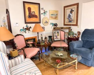 Living room with western art, armchairs, glass coffee table