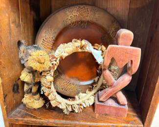 Copper charger, carved wood figure, and dried wreath