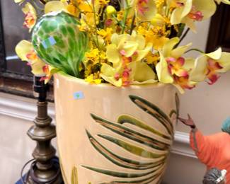 Large palm leaf floor vase with orchid arrangement