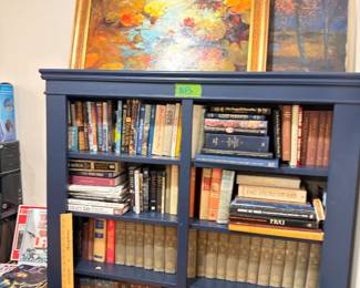 Blue bookcase with books, floral oil paintings