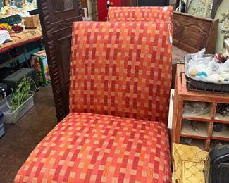 armless slipper chairs feature a distinct red and orange geometric checkered pattern