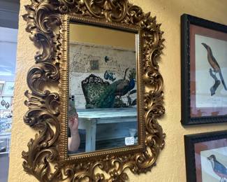 antique-style Rococo mirror features an ornate, gold-gilt frame with extensive foliate and shell-form details.