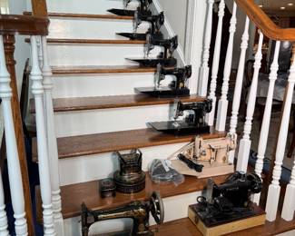 Curated collection of antique Singer, cast-iron sewing machines, some of which appear to be specialized miniature or hand-crank models