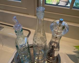 Glass cruet set with pepper mill on silver tray