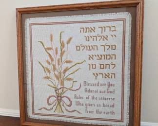 a cross-stitch sampler featuring the Hebrew blessing for bread