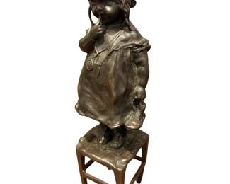 Bronze girl standing on a chair