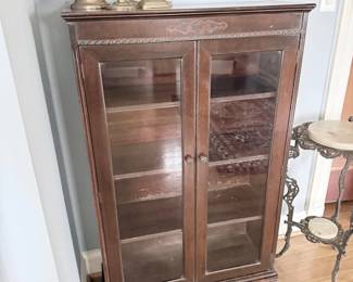 Antique oak glass-front bookcase with silver candelabra