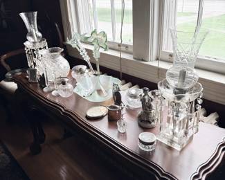 Cut glass decanters and crystal barware on console table