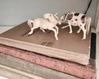 Antique cast iron horse figurines on vintage books