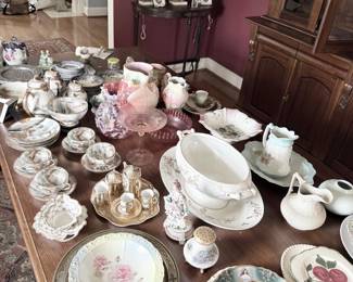 Dining table of antique porcelain, china, and serving pieces