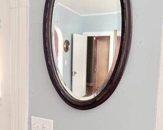Antique oval mahogany-framed beveled wall mirror