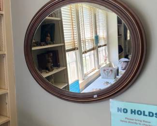 Round wood-framed wall mirror