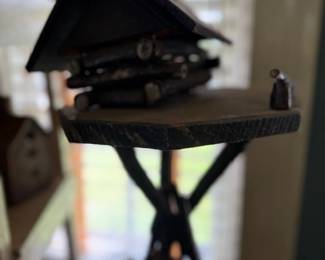 Folk art miniature cabin on twig stand