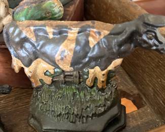 Antique cast iron cow bank on painted base