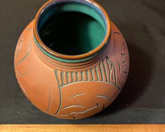 A501 - $65. Terra Cotta Vessel With Faces - Stamped . Measures 6" x 8" tall.