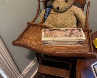 antique high chair complete with a rakish bear