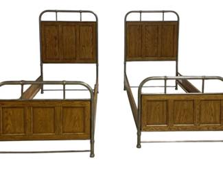 7728 - Pr Vtg Oak & Metal Twin Beds 60"x41"x79" (Description): A pair of vintage twin beds featuring oak  paneled headboards and foot boards set within  a tubular metal frame. The beds showcase a  handsome combination of warm oak wood panels  with a brass-toned or antiqued metal frame, creating a distinctive early 20th century  industrial-meets-traditional aesthetic. Each  bed measures 60 inches tall by 41 inches wide  by 79 inches long.