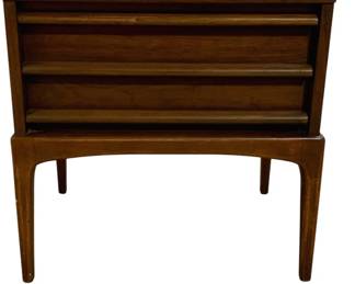 7609 - Mid-Century Lane Rhythm Walnut Nightstand (Description): Mid Century Modern walnut end table featuring  one drawer with horizontal louvered design  and tapered legs with an elegant curved  apron. The piece showcases the clean lines  and organic forms characteristic of the era. Measures 22 inches wide by 22 inches tall by  17 inches deep.