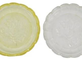 762 - 4 Heisey Multicolor Leaf Coasters 4" (Description): Set of four Heisey pressed glass coasters  featuring a central embossed leaf design with  scalloped edges. The collection includes  four distinct colors: pink/peach, pale  yellow/vaseline, clear/crystal, and green. Each coaster measures 4 inches in diameter.