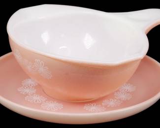 1120 - Vintage Pyrex Pink Daisy Sauce Boat w/ Plate (Description): Vintage Pyrex sauce boat with matching  underplate in the Pink Daisy pattern. The  sauce boat features a distinctive handled  design with white interior and pink exterior  decorated with white daisy motifs. The accompanying plate displays the same charming  floral pattern. Measures 2 1/2" x 6" x 7".