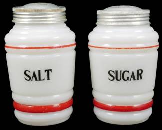 1228 - Vtg Milk Glass Salt & Sugar Shakers w/ Red 5" (Description): Vintage milk glass salt and sugar shakers  featuring red painted banding and black  lettering. Each shaker has a white opaque  glass body with a classic Art Deco ribbed  design and aluminum screw-on lids. The shakers are labeled "SALT" and "SUGAR"  rectively. Measures 5" tall.