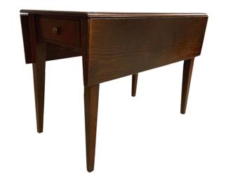 7678 - Tapered Leg Drop Leaf Table w/ Drawers (Description): Crafted in a warm walnut or fruitwood finish.  The table stands on four tapered square legs  and displays a classic design consistent  with 19th century American furniture styling.  The rectangular top extends with drop leaves on either side, allowing for versatile use.  Measures 31 inches high by 42 inches wide by  45 inches deep.