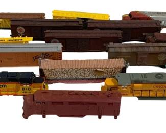 1610 - Pc. Lot HO Scale Train Cars & Parts (Description): A piece lot of HO scale train cars and parts.  The collection includes various freight  cars, locomotives, and rolling stock from  multiple railroad lines including Chessie  System B&O, Union Pacific, Frisco, and Pennsylvania Railroad. The lot features  boxcars, hoppers, flatcars, and diesel  locomotives in assorted colors including  yellow, brown, orange, and maroon. Ideal for  model railroad enthusiasts or parts for