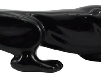 1061 - Mid Century Black Ceramic Panther Figure (Description): Mid Century black ceramic porcelain figure of  a sleek, prowling panther in a crouching  stance. The glossy black finish and  streamlined Art Deco-influenced design are  characteristic of mid-century decorative pieces. Measures 5.5" x 20" x 5".