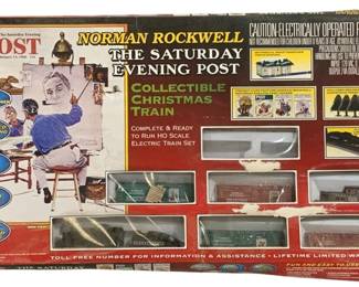 1690 - Life-Like Norman Rockwell Train Set (Description): Life-Like Trains Norman Rockwell The Saturday  Evening Post Collectible Christmas Train  set. This complete and ready to run HO scale  electric train set features Power-Loc track,  a snow-covered Santa's Landing Station, decorated Christmas trees, and freight cars  featuring Norman Rockwell artwork. The set  includes a deluxe power pack with variable  speed and reverse. The box displays the  iconic February 13, 1960 Saturday Evening