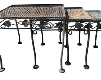 7692 - Metal Outdoor Nesting Tables (Description): Set of three outdoor nesting tables featuring  decorative grape leaf and vine scrollwork  along the aprons. Each table has a mesh top  surface with a raised lip edge and stands on  gracefully curved cabriole legs ending in pad feet. The metal displays a weathered patina  consistent with outdoor use. Largest table  measures 16" x 19" x 19".